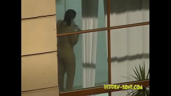 نئے A girl washes in the shower, and we see her through the window گرم کلپس